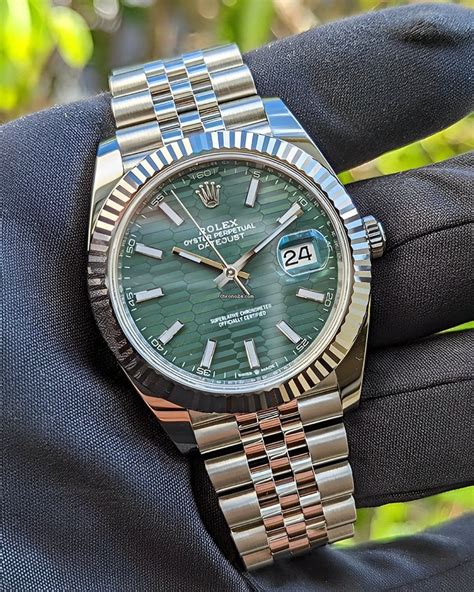 silver rolex with green face.